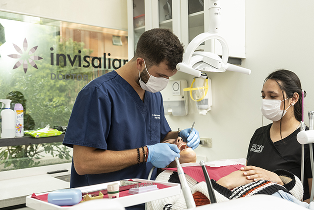 Dentista instalando alineadores Invisalign - Clínica dental Pio X